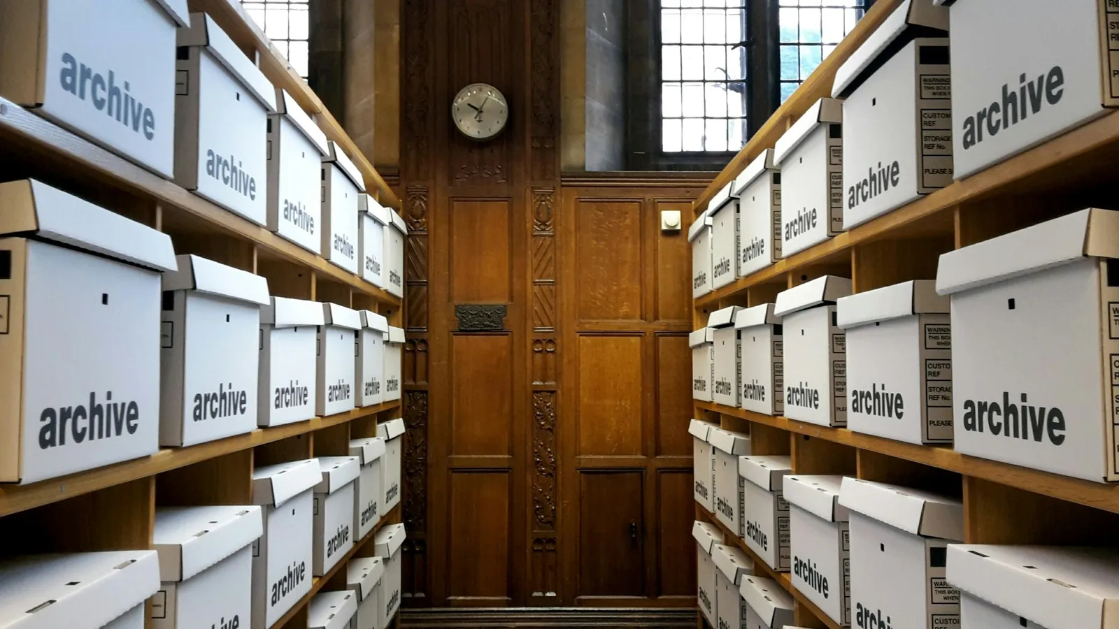 Rows of labeled archive boxes on shelves, a company's own records